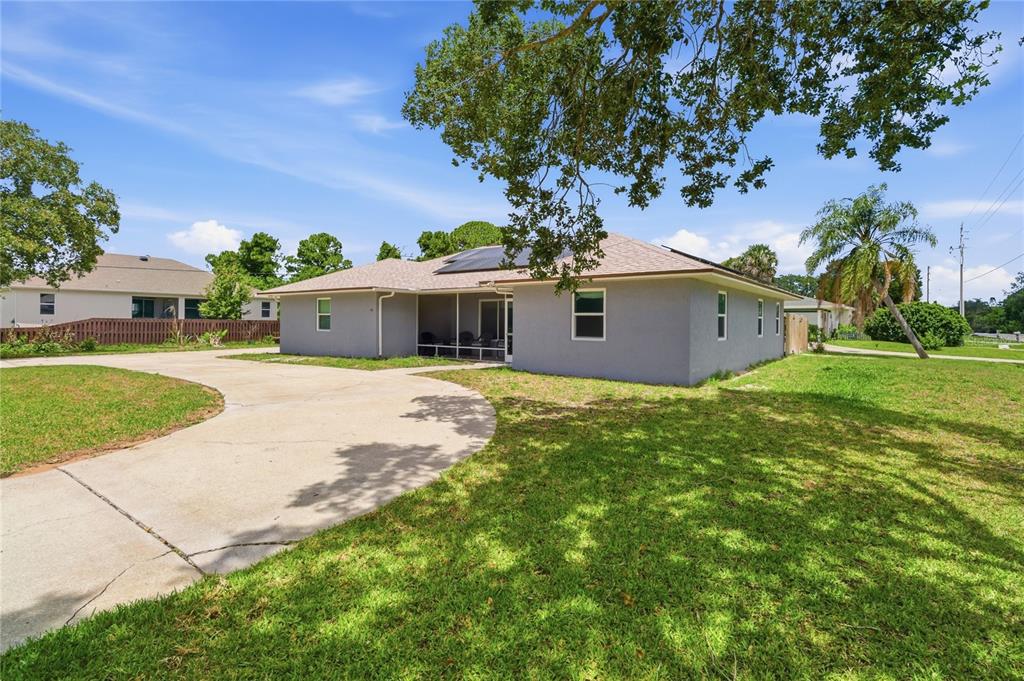 A gray single-story house with a concrete driveway and a screened-in back porch — 602 LAKE DRIVE, SEBASTIAN, FL