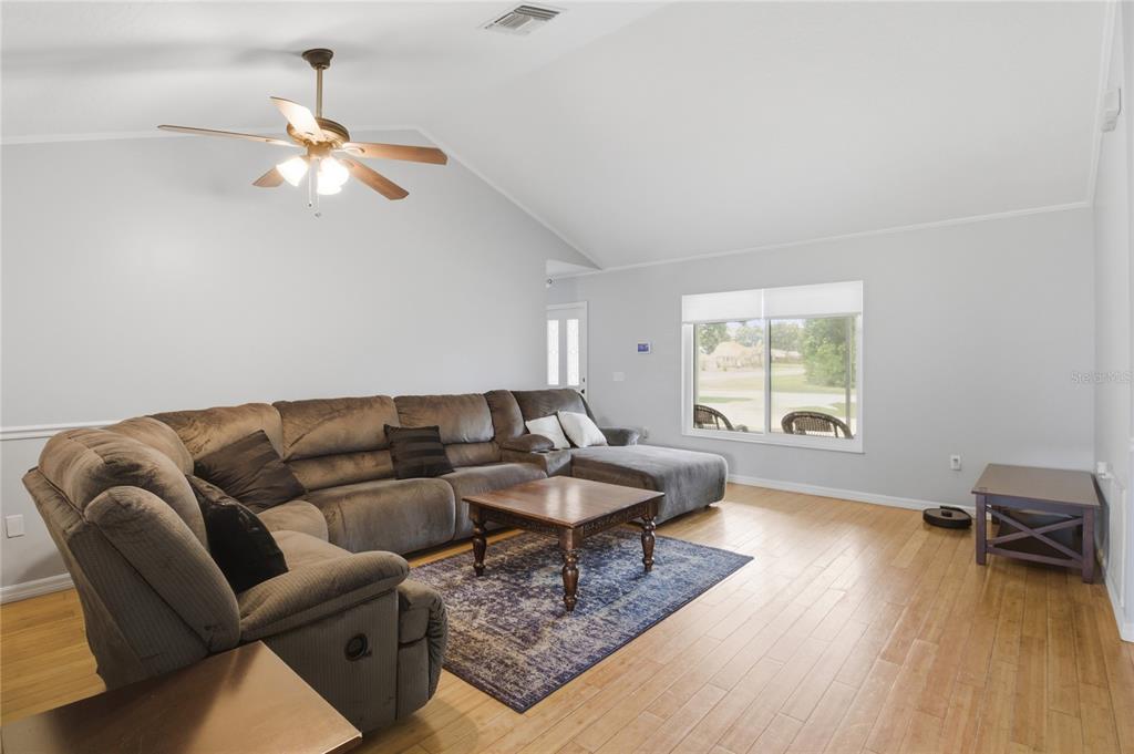 A living room features a large sectional sofa, a coffee table, and a vaulted ceiling — 602 LAKE DRIVE, SEBASTIAN, FL