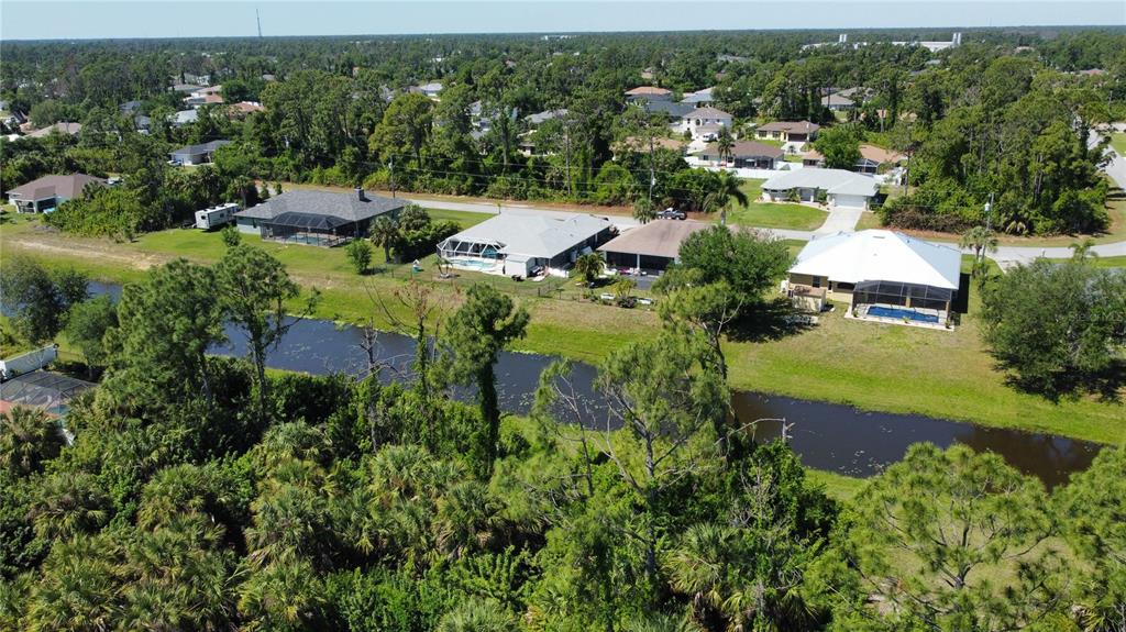 An aerial view shows several suburban houses with swimming pools situated along a canal — Lot 6, GARDENSIDE CIRCLE, NORTH PORT, FL