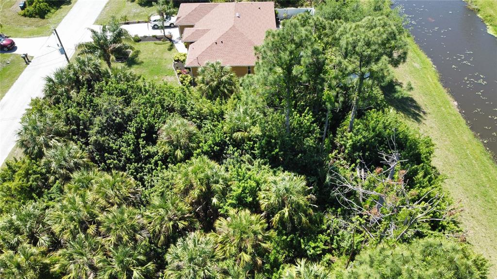 An aerial view shows a house with a brown roof surrounded by dense trees — Lot 6, GARDENSIDE CIRCLE, NORTH PORT, FL