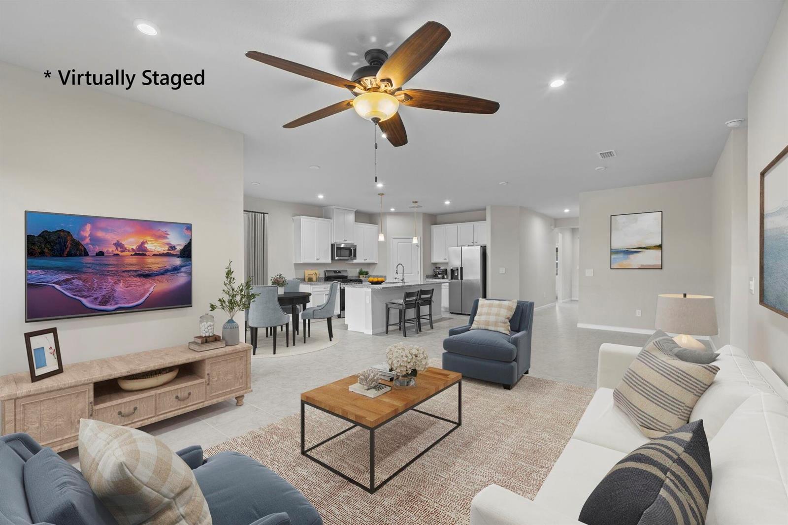 This virtually staged open-concept living room features a kitchen with an island and dining area — 93 Judah Lane, Sebastian FL 32958, SEBASTIAN, FL