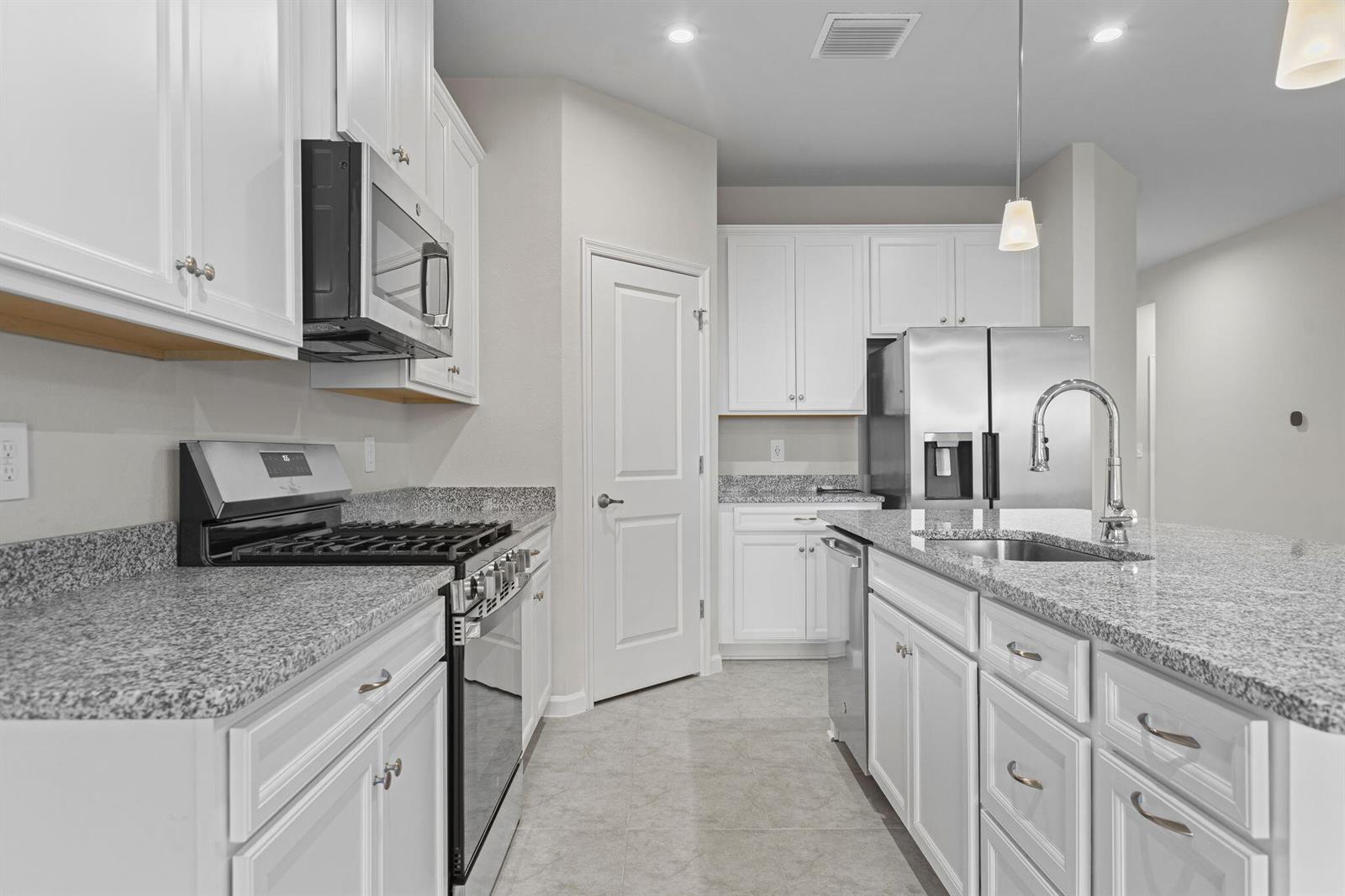 A kitchen features white cabinets, granite countertops, stainless steel appliances, and a central island — 93 Judah Lane, Sebastian FL 32958, SEBASTIAN, FL