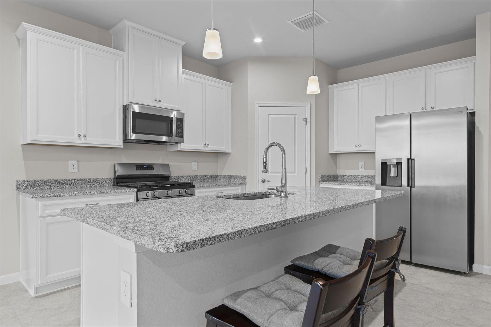 A kitchen with white cabinets, granite countertops, stainless steel appliances, and a central island — 93 Judah Lane, Sebastian FL 32958, SEBASTIAN, FL