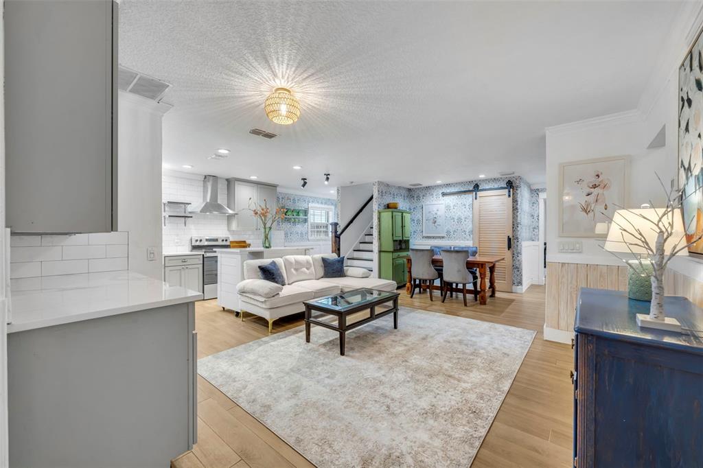 A bright hallway features light wood flooring, wainscoting, and a console table with a vase — 1611 CHESTNUT AVENUE, WINTER PARK, FL