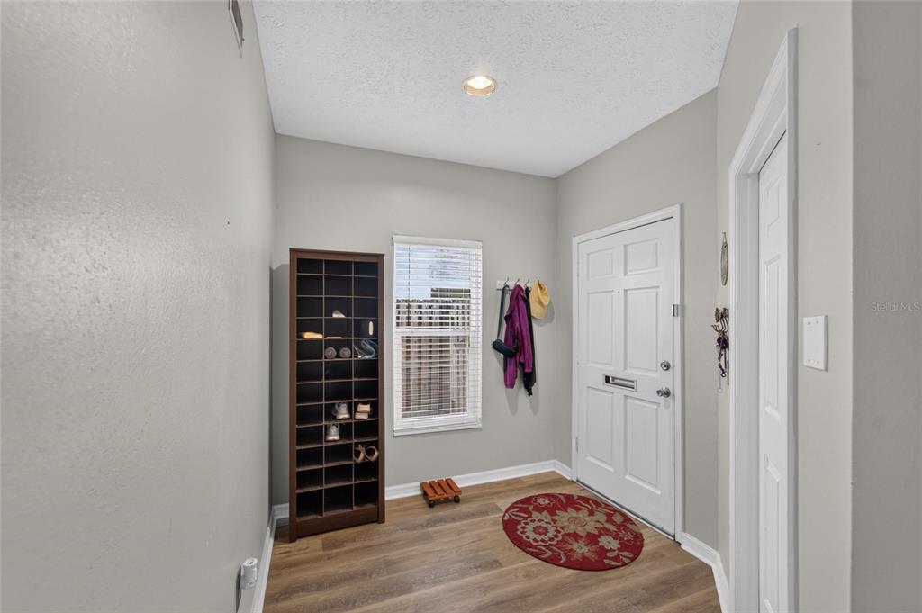 An entryway features wood-look flooring, a shoe rack, a window, and a white front door — 3219 W SANTIAGO STREET UNIT B, TAMPA, FL