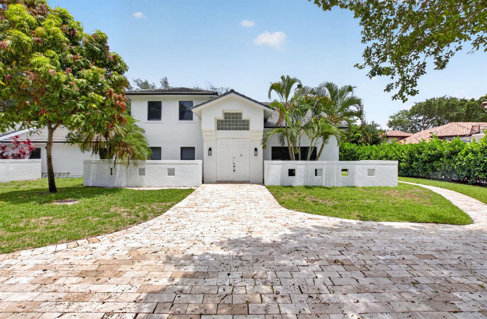 A white two-story house features a stone paver walkway and a low decorative wall — 8044 Twin Lake Drive, Boca Raton FL 33496, BOCA RATON, FL