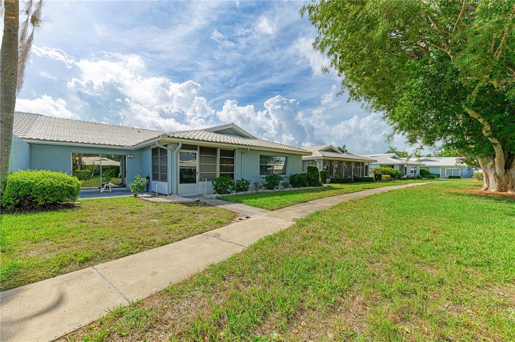 A light blue single-story house with a tiled roof and a concrete walkway outside — 804 67TH STREET W, BRADENTON, FL