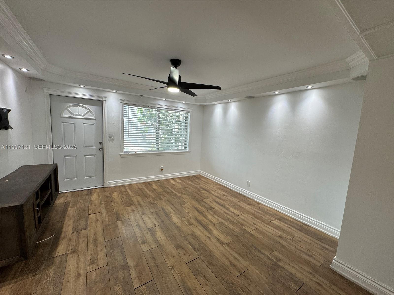 An empty room features wood-look flooring, a ceiling fan, and recessed lighting along the walls — 2000 Buchanan St # 3, Hollywood FL 33020, HOLLYWOOD, FL