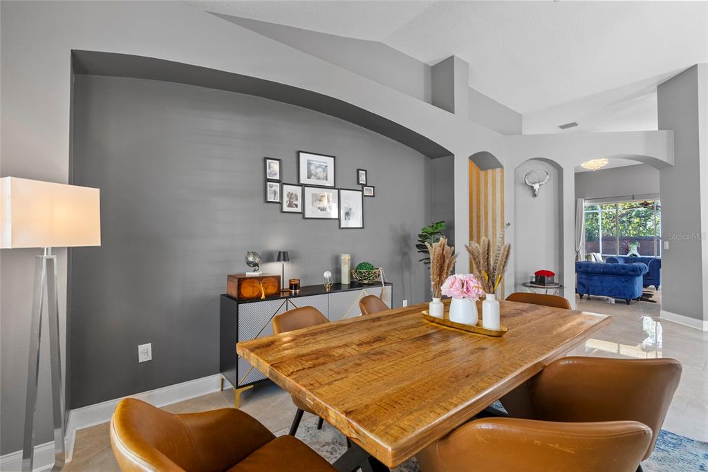 A dining room features a wooden table, leather chairs, and a gray accent wall niche — 10602 ROCHESTER WAY, TAMPA, FL