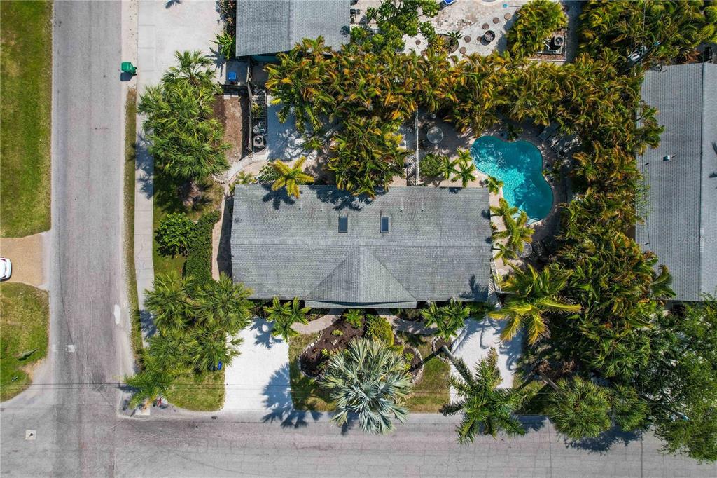 An aerial view shows a house with a gray roof, a pool, and surrounding palm trees — 76 N SHORE DRIVE, ANNA MARIA, FL