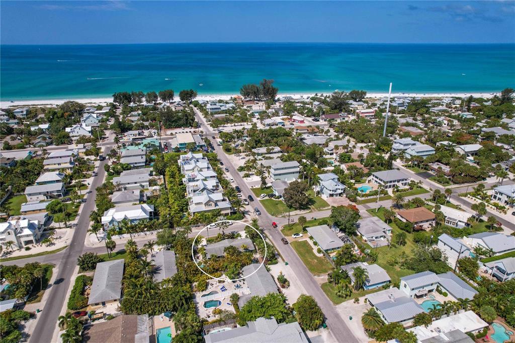 An aerial view shows a residential neighborhood near the beach with a circled single-story house — 76 N SHORE DRIVE, ANNA MARIA, FL