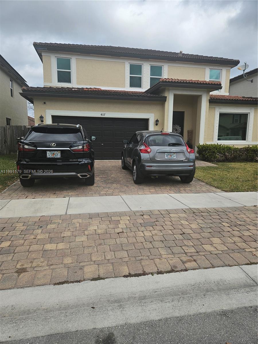 A two-story house with a paved driveway and two parked cars in front — 4117 NE 21st St, Homestead FL 33033, HOMESTEAD, FL
