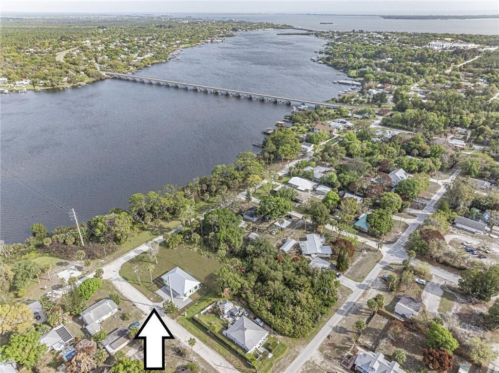 An aerial view shows a residential property near a large lake and a long bridge — 12906 83rd Avenue, Sebastian FL 32958, SEBASTIAN, FL