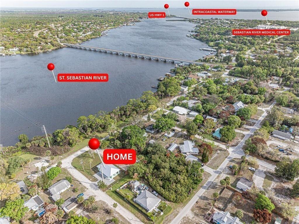 An aerial view shows a house near the St. Sebastian River, bridge, and coastal waterway — 12906 83rd Avenue, Sebastian FL 32958, SEBASTIAN, FL