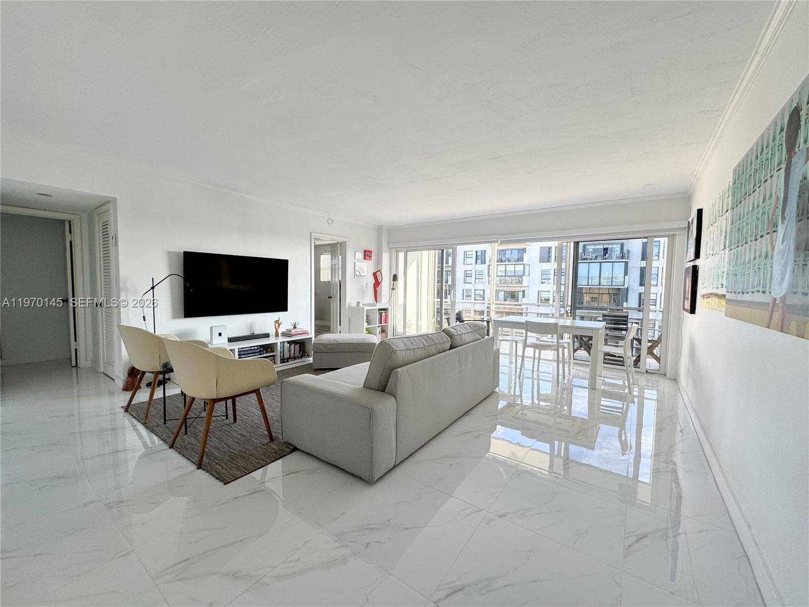 A living room features white marble floors, a grey sofa, and a balcony with city views — 555 Crandon Blvd # 82, Key Biscayne FL 33149, KEY BISCAYNE, FL
