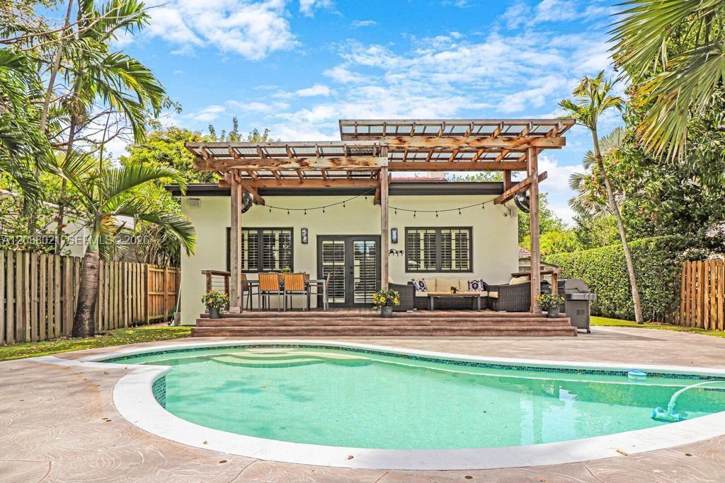 A backyard features a swimming pool, a wooden deck, and a pergola-covered patio area — 111 SW 29th Rd # 111, Miami FL 33129, MIAMI, FL