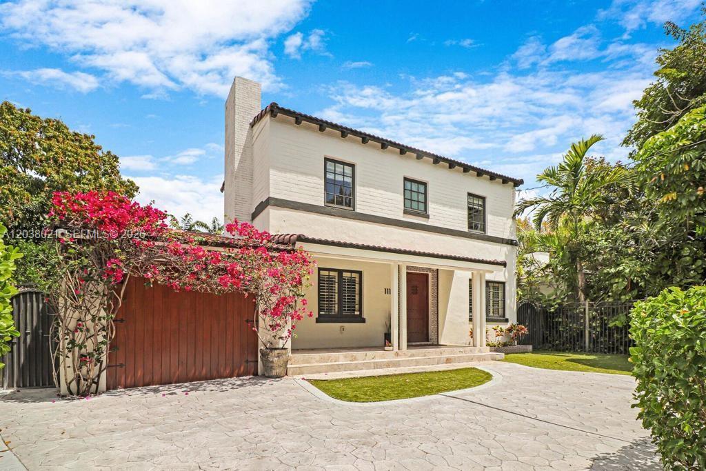A two-story white stucco house features a wooden garage door, bougainvillea, and a paved driveway — 111 SW 29th Rd # 111, Miami FL 33129, MIAMI, FL