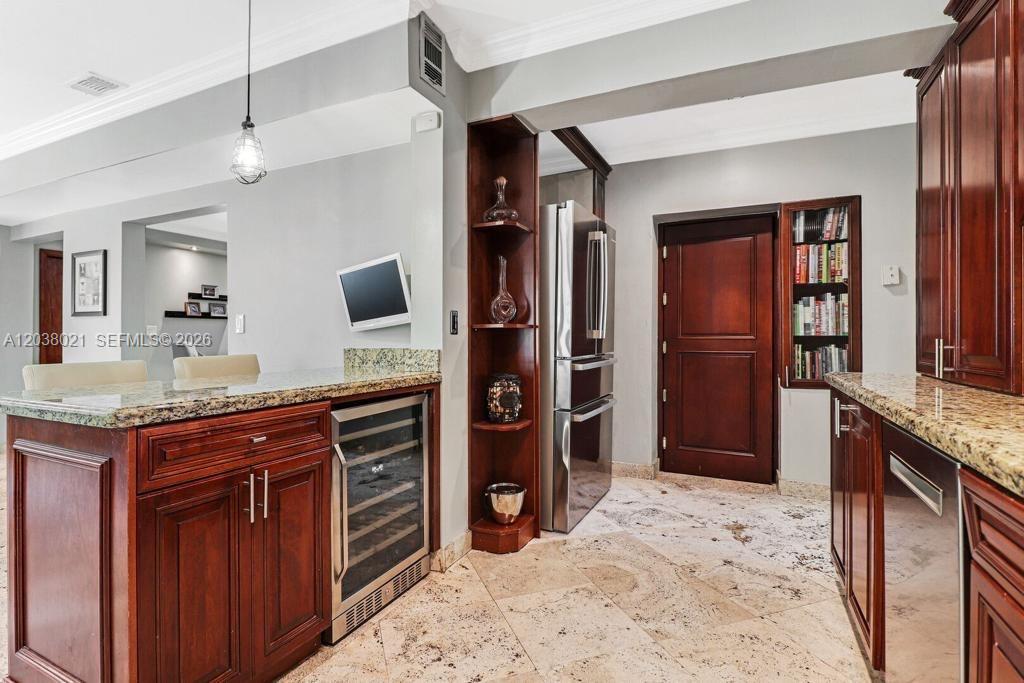 A kitchen features dark wood cabinets, granite countertops, a wine cooler, and stone tile flooring — 111 SW 29th Rd # 111, Miami FL 33129, MIAMI, FL