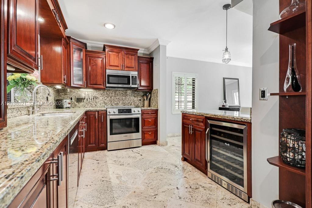 A kitchen features cherry wood cabinets, granite countertops, stainless steel appliances, and a wine cooler — 111 SW 29th Rd # 111, Miami FL 33129, MIAMI, FL