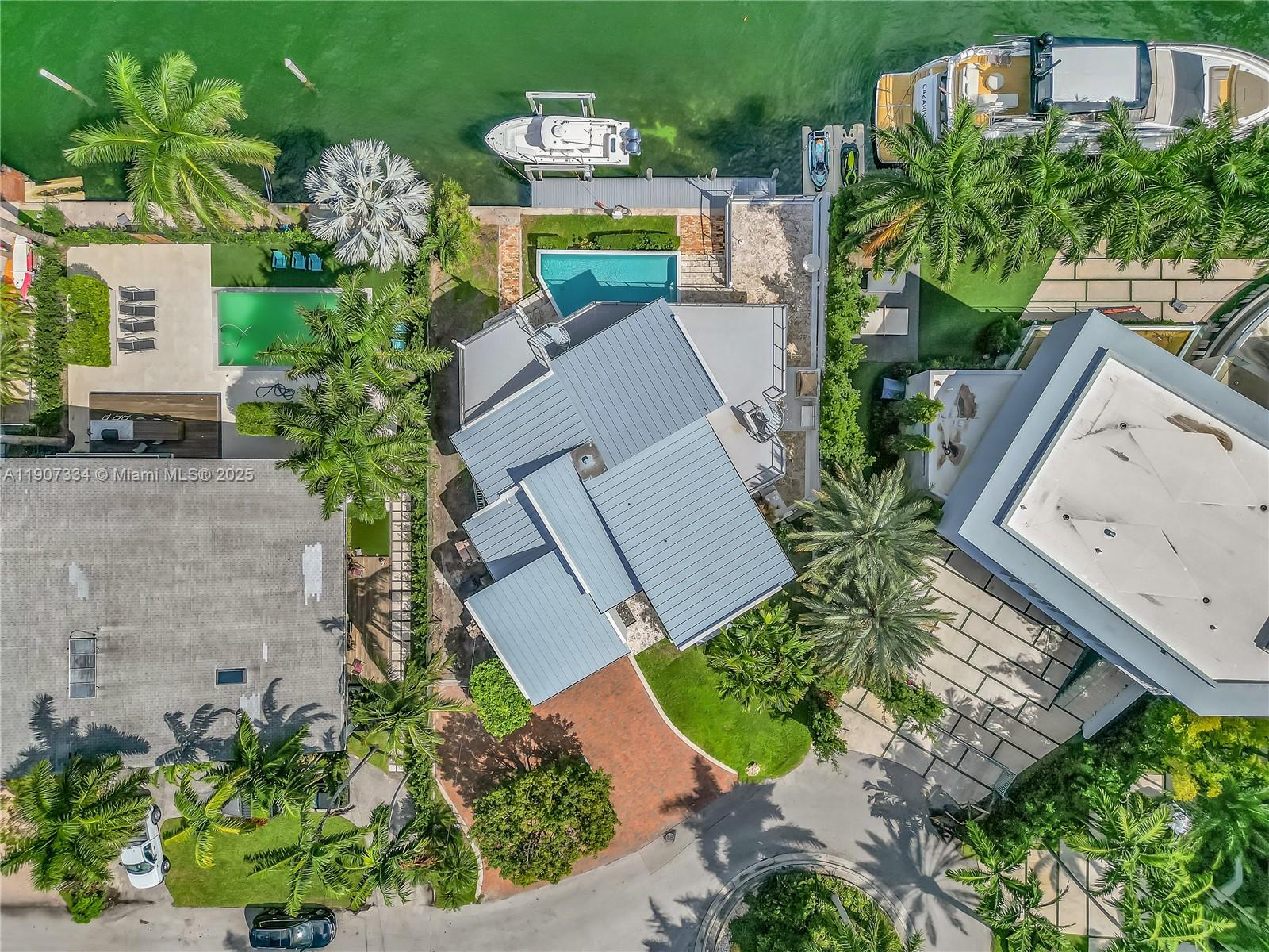 An aerial view shows a waterfront house with a metal roof, pool, and boat dock — 2089 NE 121st Rd, North Miami FL 33181, NORTH MIAMI, FL