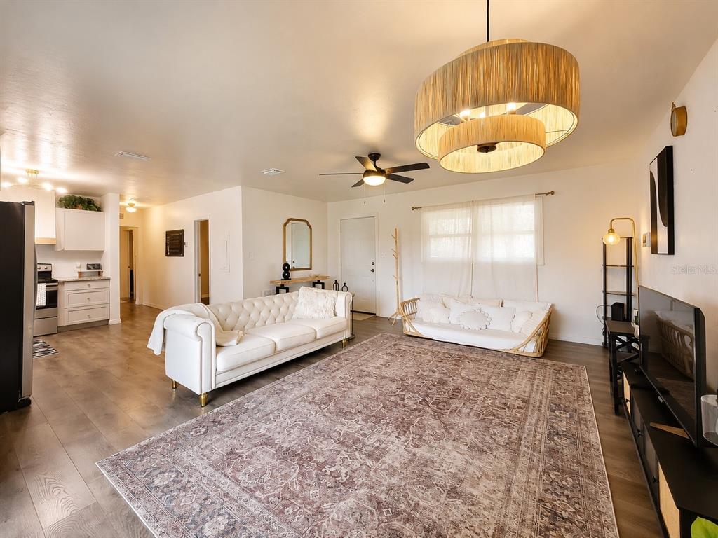 A living room features a tufted white sofa, a daybed, and a large patterned rug — 2524 NE 5TH PLACE, GAINESVILLE, FL