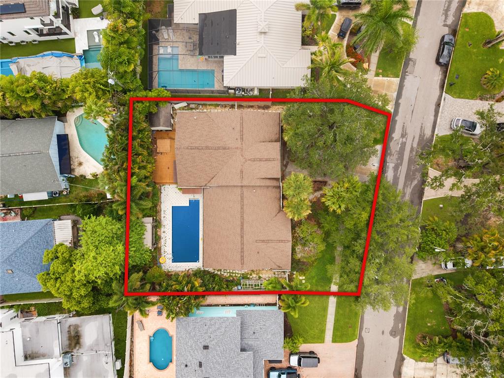 An aerial view shows a residential property with a house, swimming pool, and mature trees — 410 ERIE AVENUE, TAMPA, FL