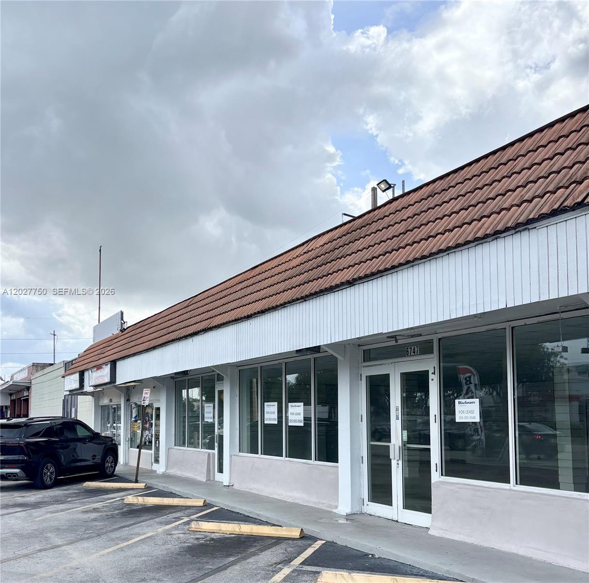 The exterior of a commercial strip mall building features a brown tile roof and glass storefronts — 6741 SW 8th St # 6747, Miami FL 33144, MIAMI, FL