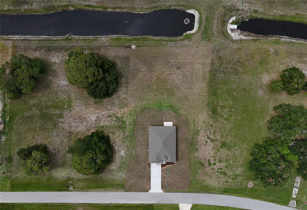 An aerial view shows a single-story house on a rectangular lot bordering a canal — 7825 PINE GLEN ROAD, SEBRING, FL