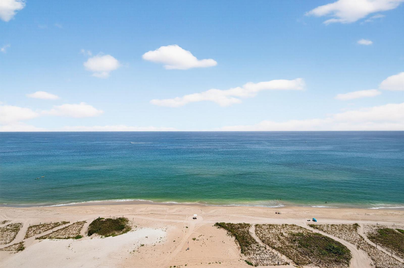 An aerial view of a sandy beach meeting the blue ocean under a cloudy sky — 900 N Ocean Boulevard # 1702, Pompano Beach FL 33062, POMPANO BEACH, FL