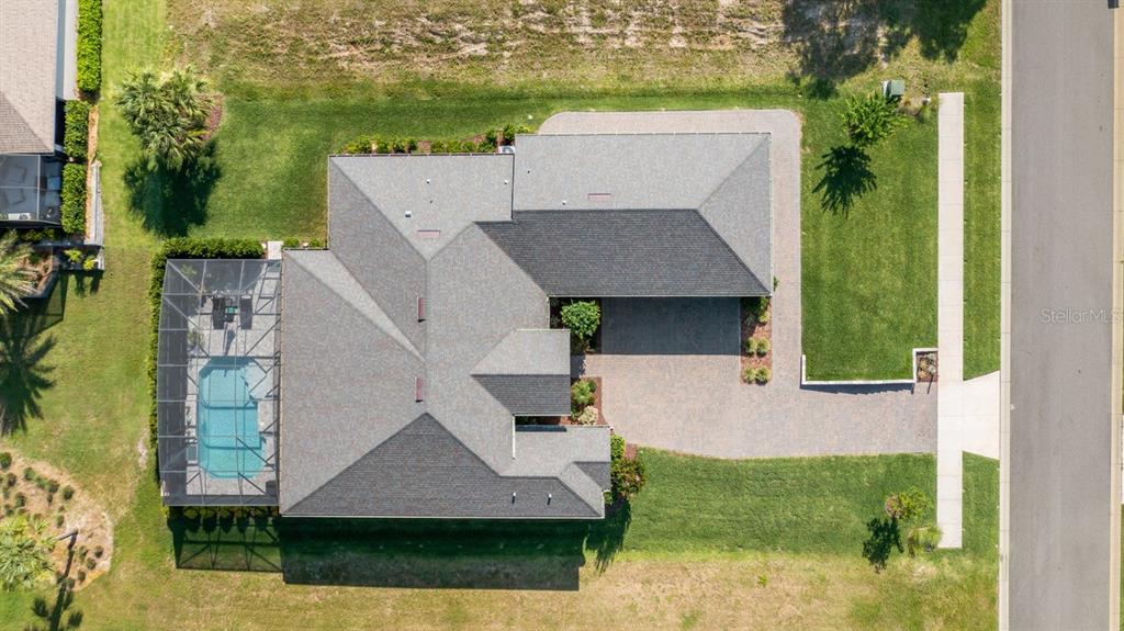 A single-story house with a paved driveway, tan stucco exterior, and a manicured lawn — 4008 PINNACLE PLACE COURT, LADY LAKE, FL