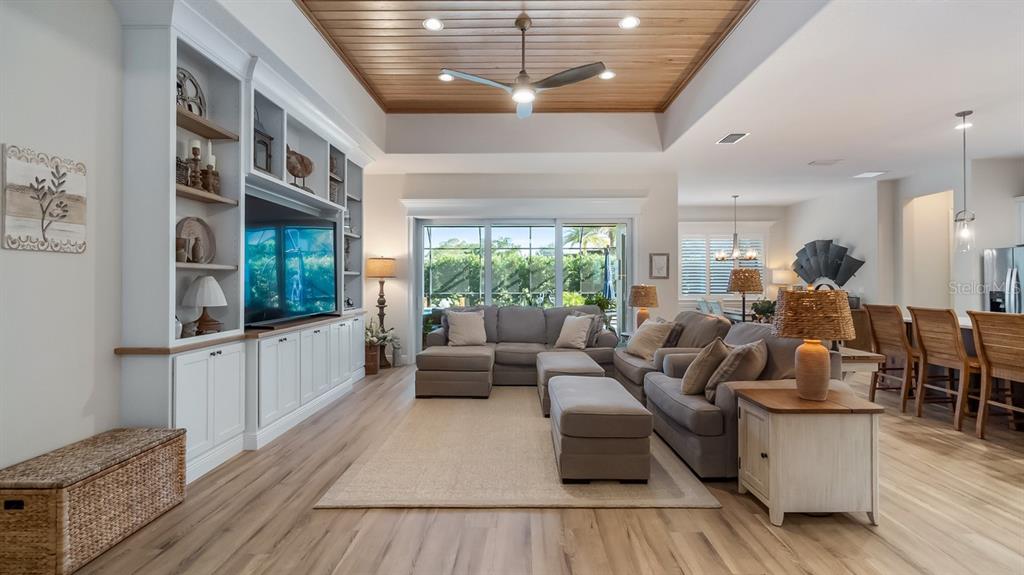 A screened-in swimming pool with a water feature and paver deck overlooking a grassy lawn — 4008 PINNACLE PLACE COURT, LADY LAKE, FL