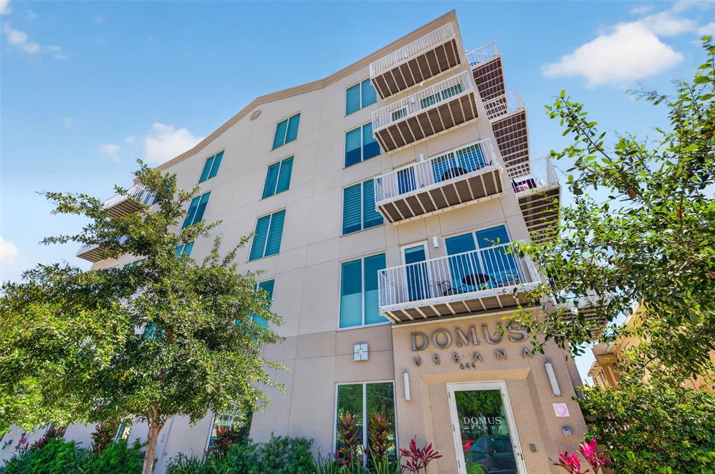 A low-angle exterior view of a multi-story apartment building with balconies and large windows — 644 3RD AVENUE S UNIT 202, ST PETERSBURG, FL