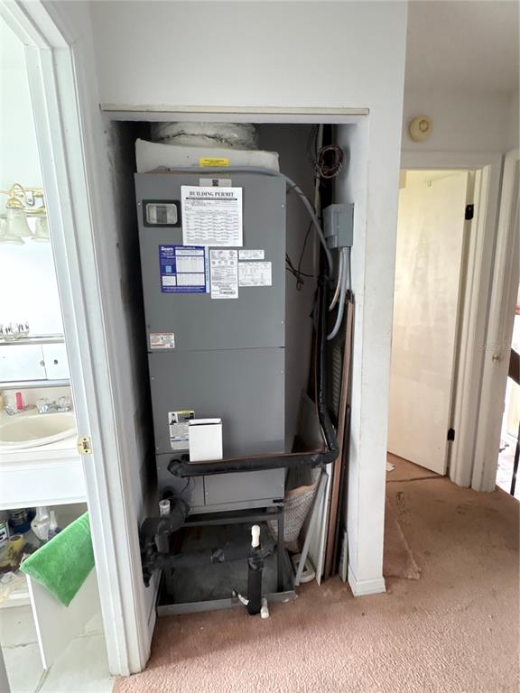 An indoor HVAC air handler unit is installed inside a small utility closet — 631 DRIVER CIRCLE, KISSIMMEE, FL