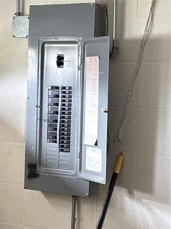 An electrical breaker panel is mounted on a white concrete block wall — 631 DRIVER CIRCLE, KISSIMMEE, FL