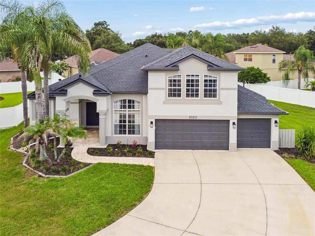 An aerial view of a two-story suburban house with a gray roof and driveway — 3102 WHITE PHEASANT PLACE, VALRICO, FL