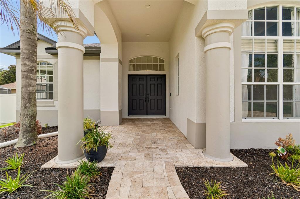 A paved walkway leads to the front entrance of a house with two large columns — 3102 WHITE PHEASANT PLACE, VALRICO, FL
