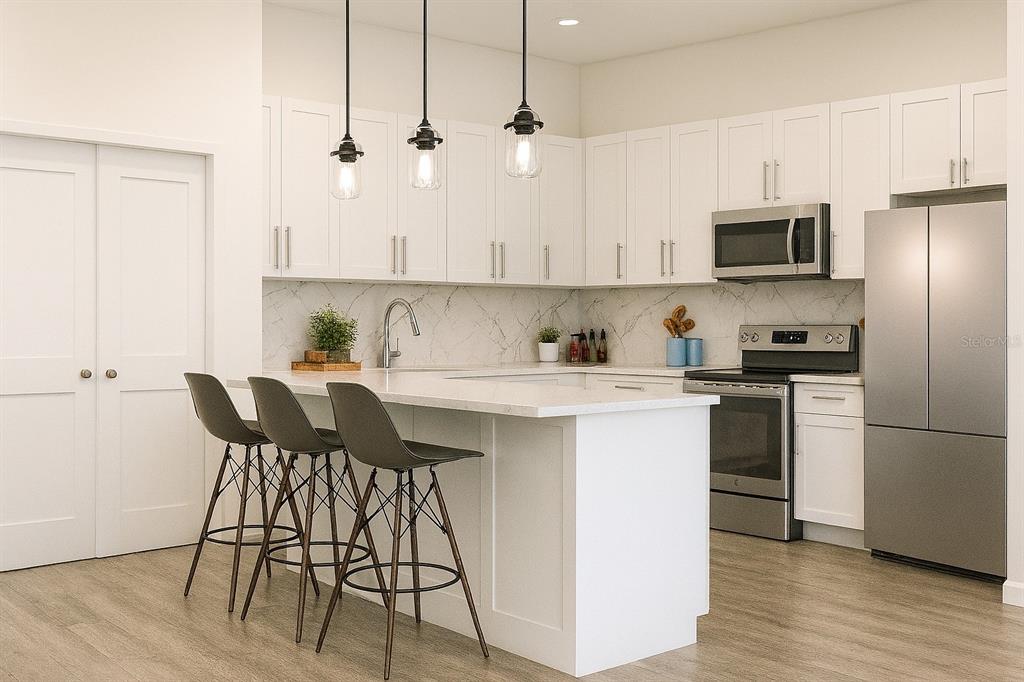 A modern kitchen features white cabinetry, a marble-look backsplash, stainless steel appliances, and a breakfast bar — 2160 TOPSY TERRACE, NORTH PORT, FL