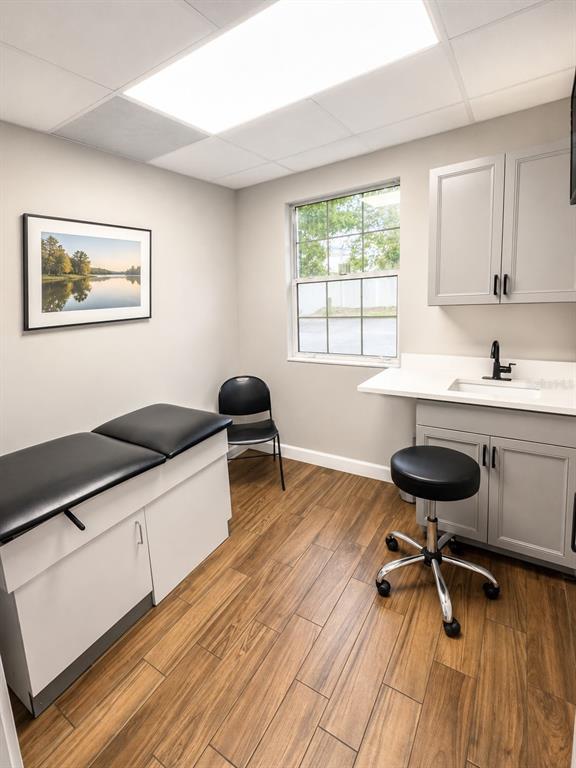 A medical exam room features a treatment table, a sink, and wood-look tile flooring — 2506 ACORN STREET UNIT A-B, FORT PIERCE, FL
