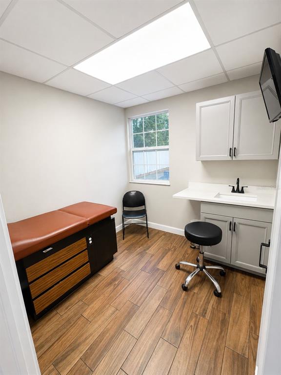 A medical exam room features a treatment table, a sink, and wood-look tile flooring — 2506 ACORN STREET UNIT A-B, FORT PIERCE, FL