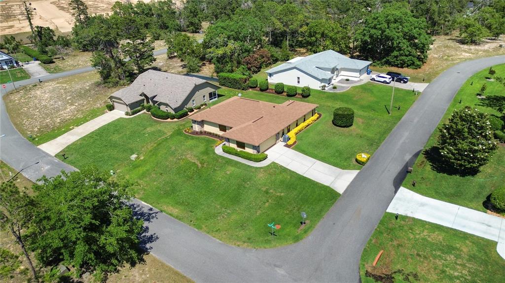 An exterior view of a single-story house with a tan facade and a brown roof — 12001 GRANADA PLACE, WEEKI WACHEE, FL
