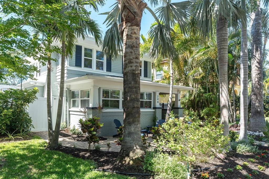 A two-story house with light green siding, a front porch, and surrounding palm trees — 248 14TH AVENUE NE, ST PETERSBURG, FL
