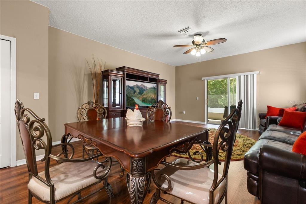 A dining area with a wooden table and chairs sits in front of a media console — 2721 WALDEN WOODS DRIVE, PLANT CITY, FL