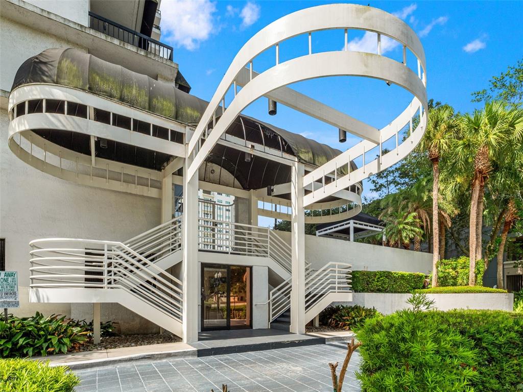 An exterior view of a building entrance featuring a white curved architectural frame and stairs — 530 E CENTRAL BOULEVARD UNIT 405, ORLANDO, FL