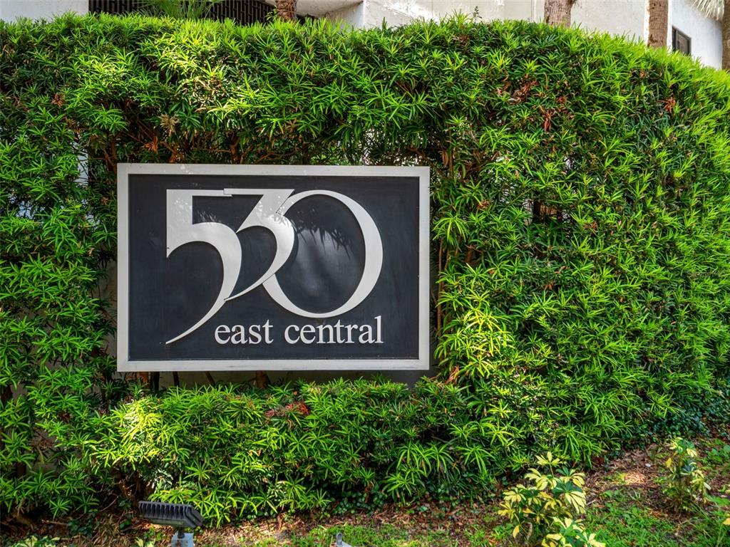 A sign reading 530 east central is mounted on a hedge in front of a building — 530 E CENTRAL BOULEVARD UNIT 405, ORLANDO, FL