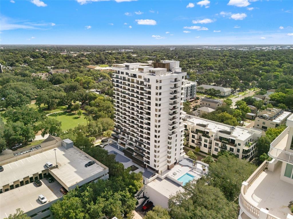 An aerial view shows a tall white residential building with balconies next to a pool — 530 E CENTRAL BOULEVARD UNIT 405, ORLANDO, FL
