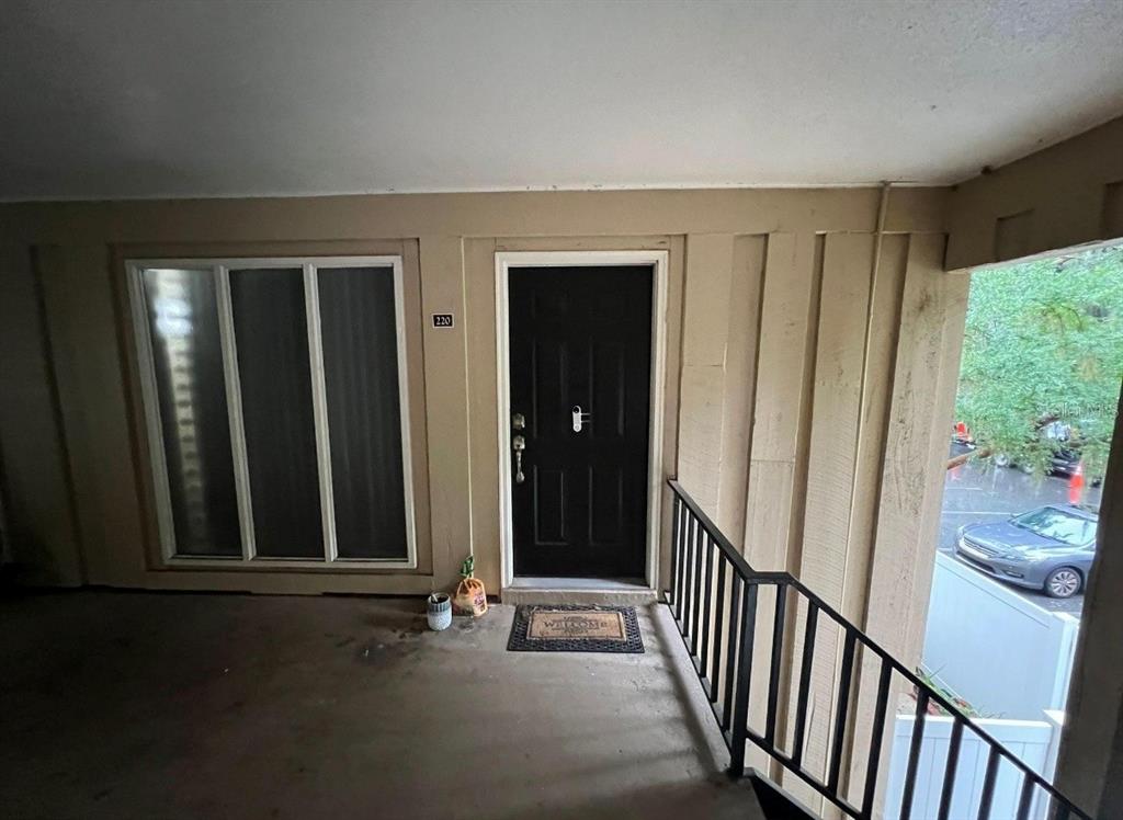 An exterior view of a residential unit entrance with a black door and window — 507 NW 39TH ROAD UNIT 220, GAINESVILLE, FL
