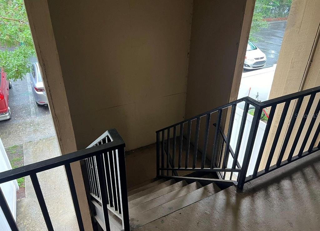 An outdoor staircase with black metal railings leads down from a covered landing — 507 NW 39TH ROAD UNIT 220, GAINESVILLE, FL