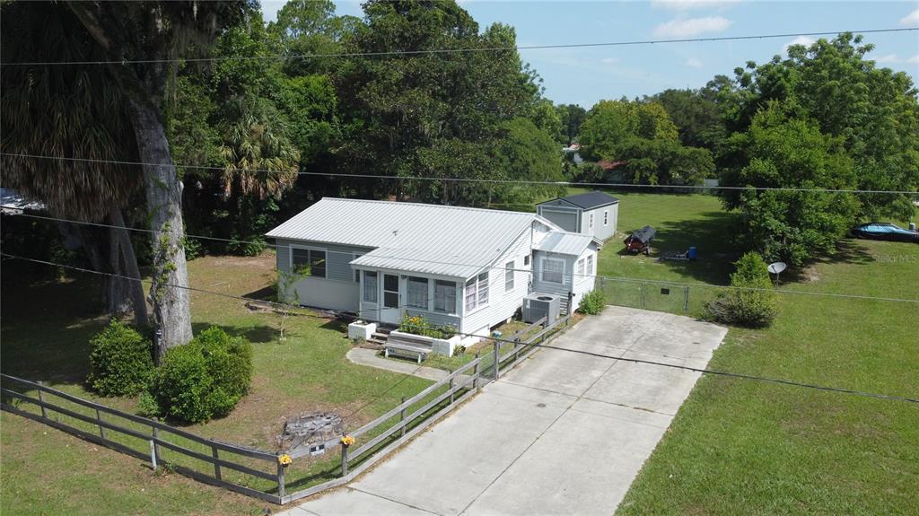 An aerial view of a single-story house with a metal roof and a concrete driveway — 2995 NE 97TH STREET ROAD, ANTHONY, FL