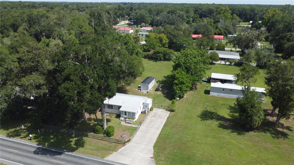An aerial view shows a single-story house with a concrete driveway and a detached shed — 2995 NE 97TH STREET ROAD, ANTHONY, FL