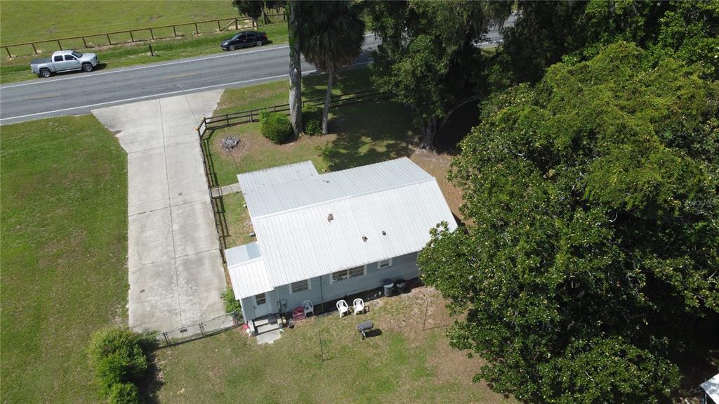 An aerial view shows a small house with a metal roof and a concrete driveway — 2995 NE 97TH STREET ROAD, ANTHONY, FL